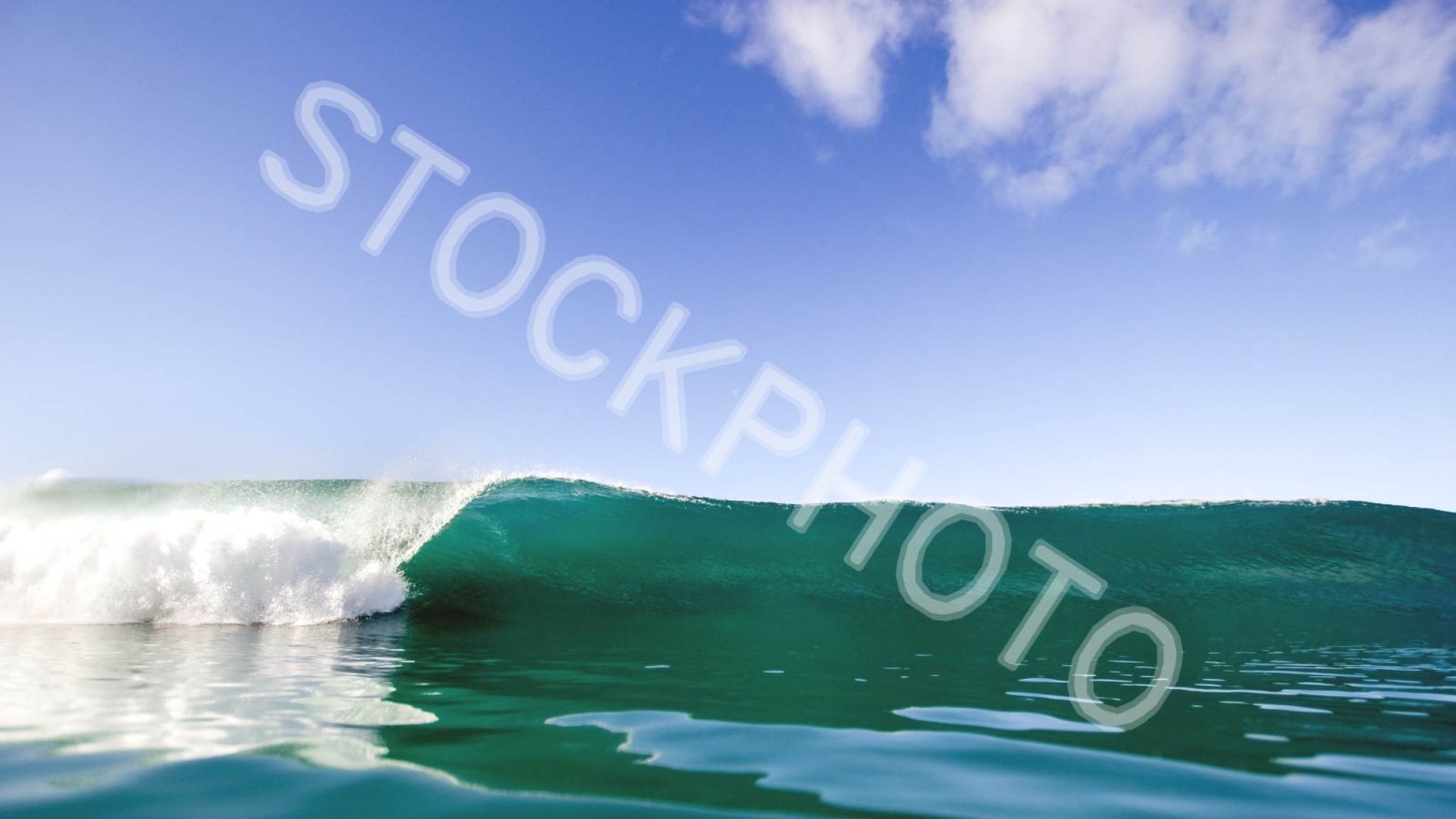 Before: A single large diagonal text stamp, STOCKPHOTO, across the sky and the sea
