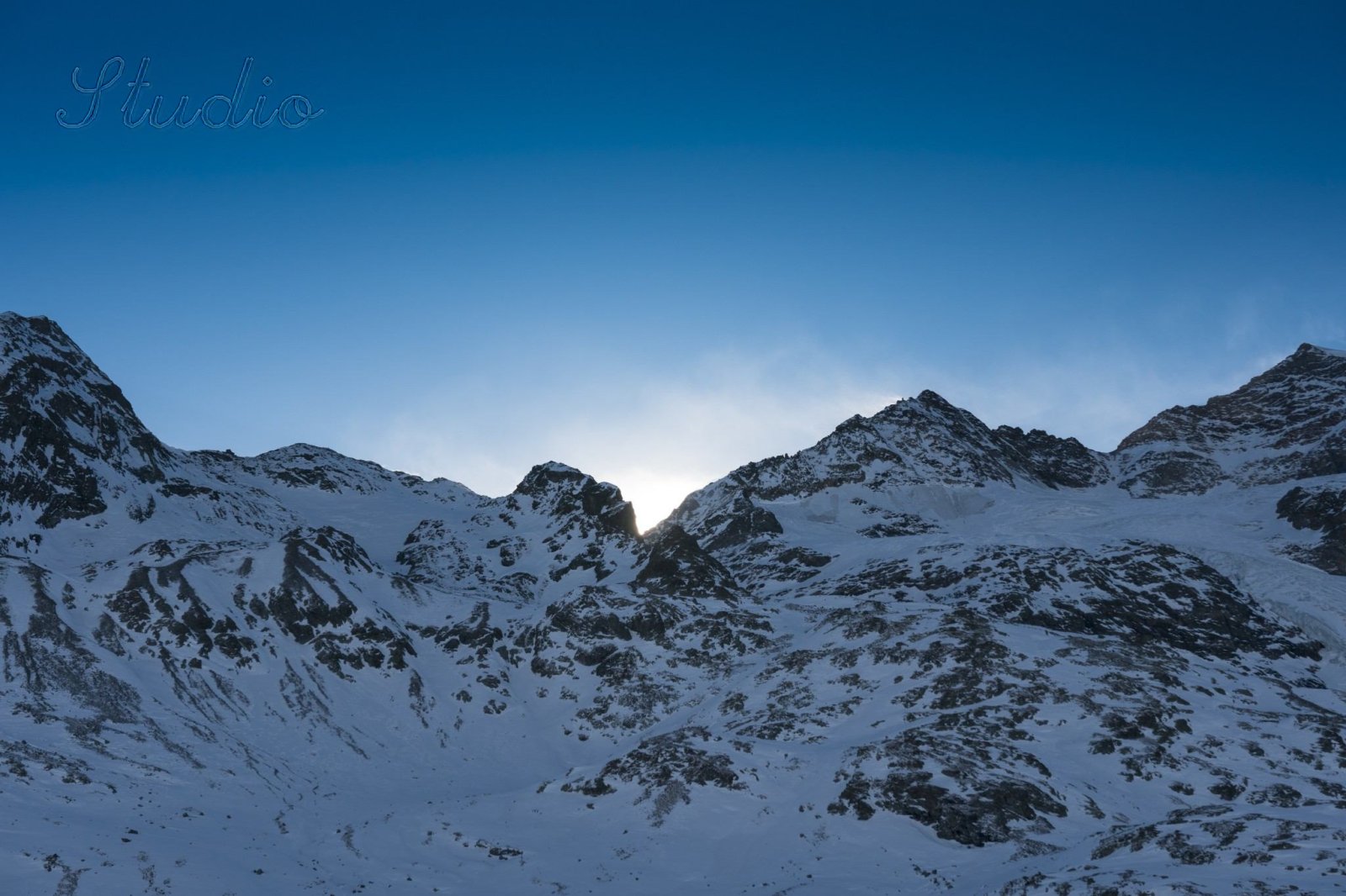 After: the mountain scene with the signature removed; a faint ghost of the script remains