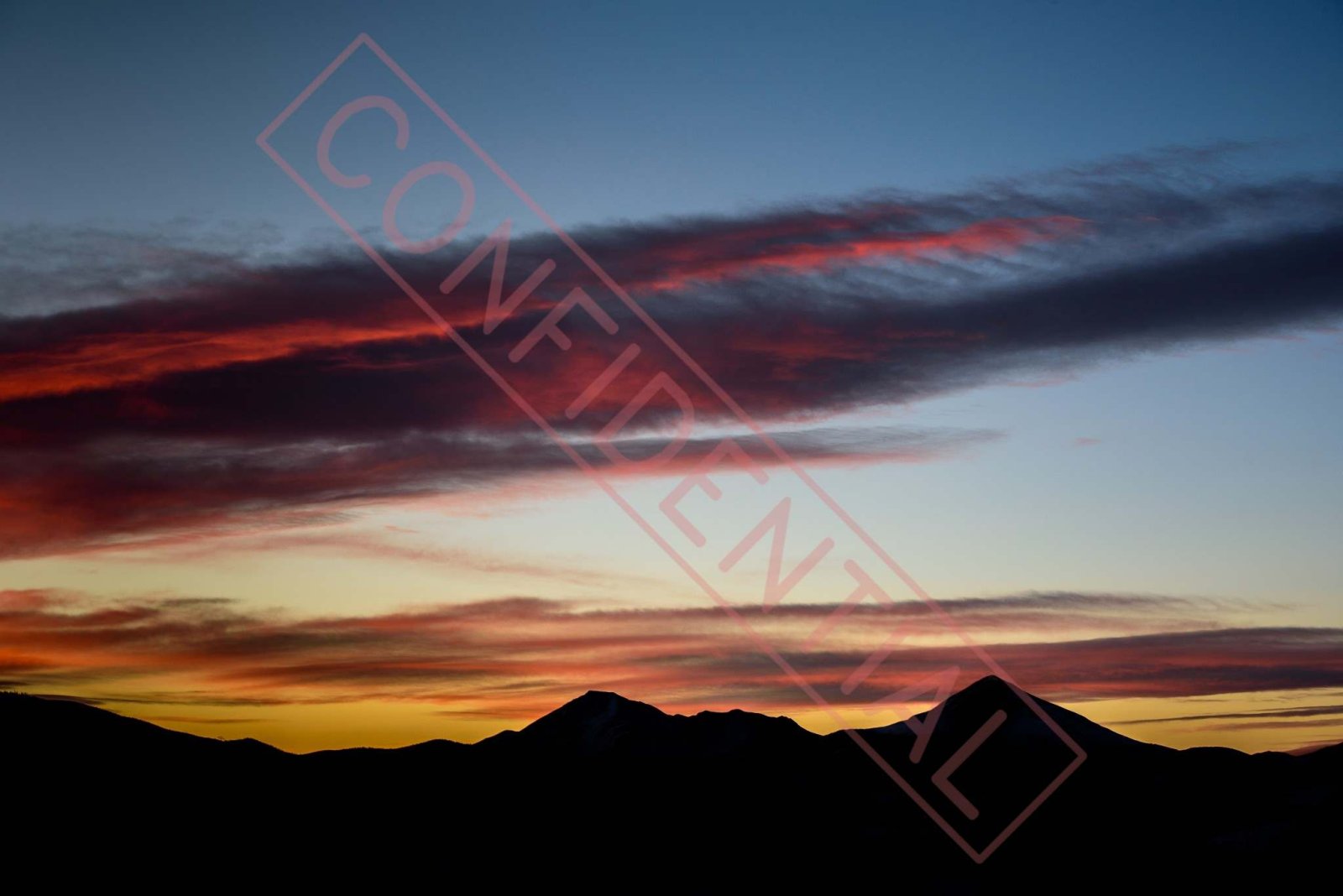 Before: A diagonal boxed CONFIDENTIAL stamp across a sunset sky and mountain silhouette